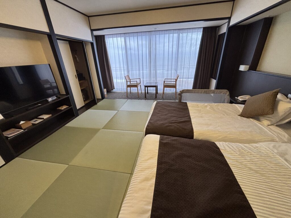 亀の井ホテル 九十九里の部屋全体。奥には休憩できる椅子と机がある